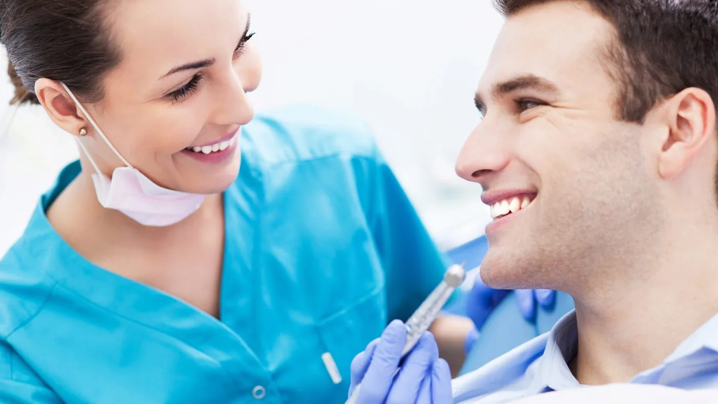 Médica dentista sorridente a conversar com um paciente